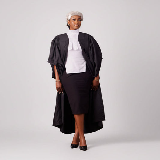 Person wearing a black robe and white wig on a white background